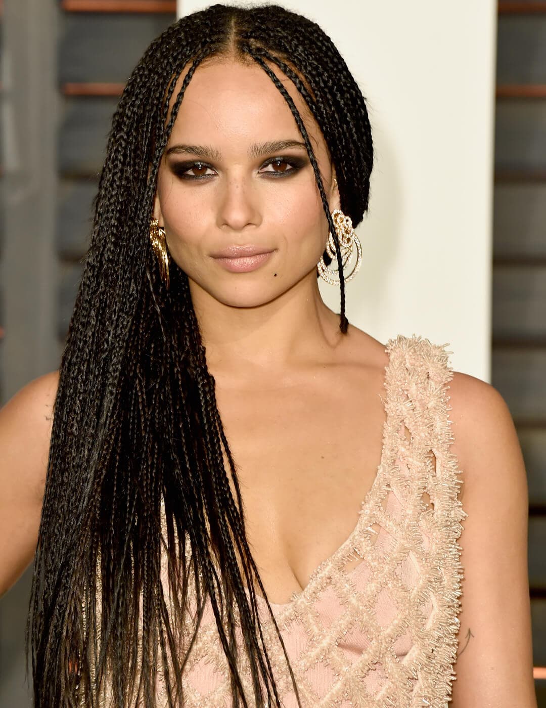 Zoe Kravitz in a nude pink, fringed dress rocking her micro braided hairstyle