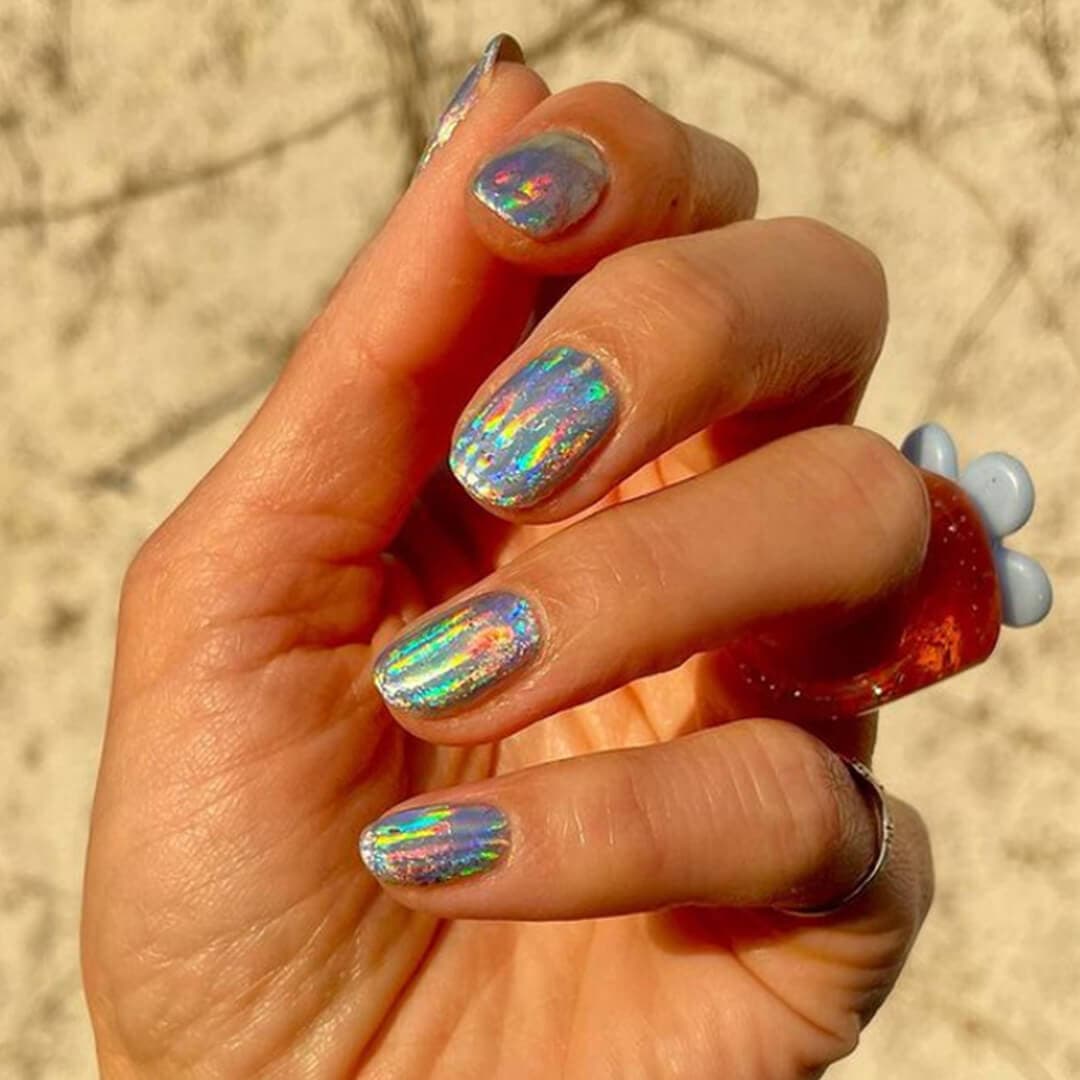 Close-up of a woman's hand with rainbow foil nail art