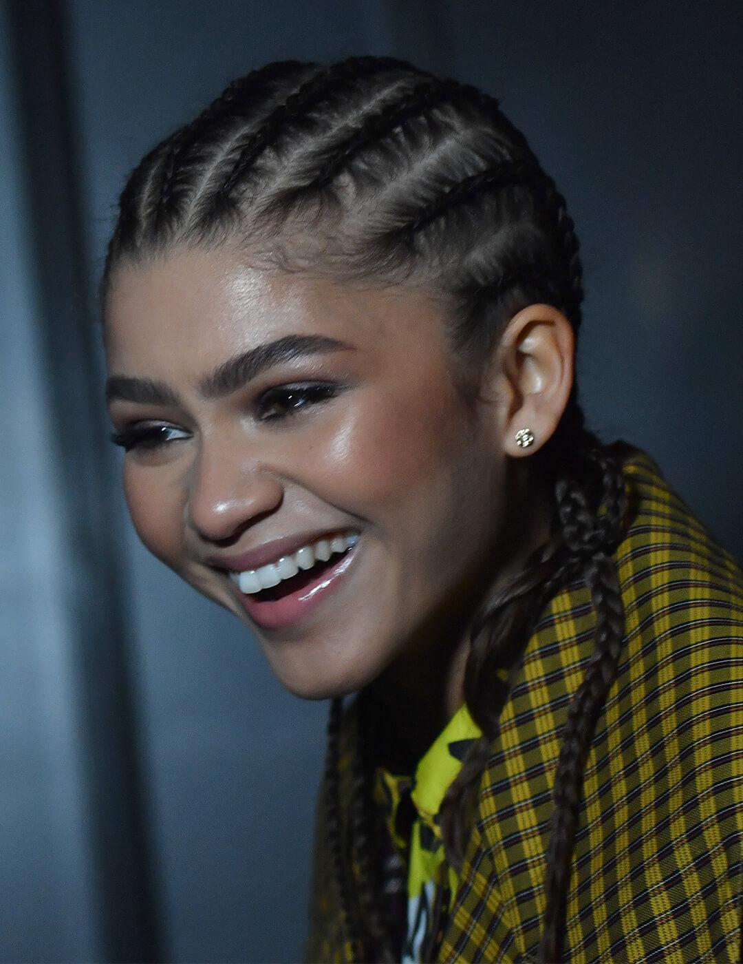 Zendaya in a yellow plaid jacket and classic cornrows hairstyle