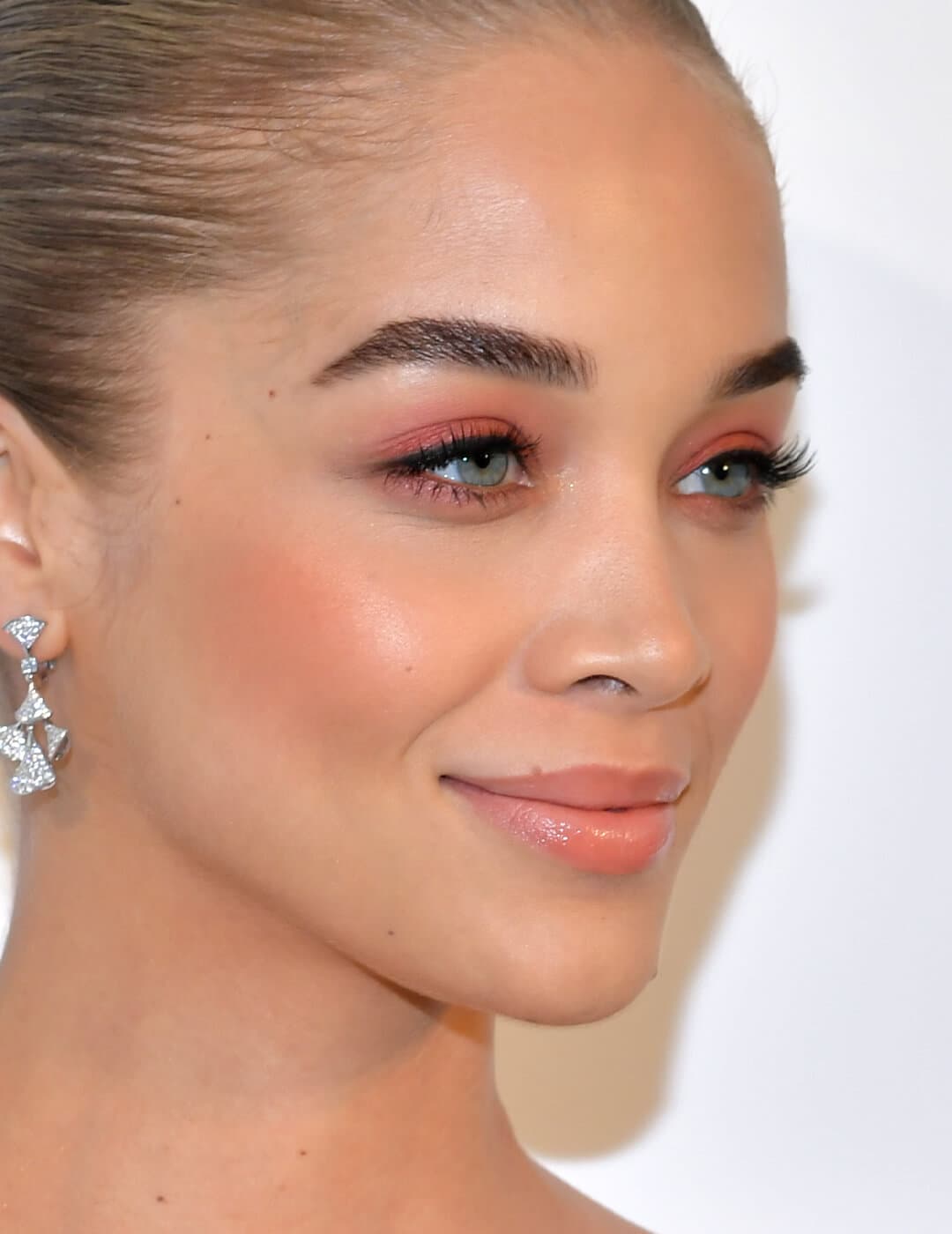 Jasmine Sanders rocking a pinky sunset eyeshadow look paired with a peachy blush and lipstick