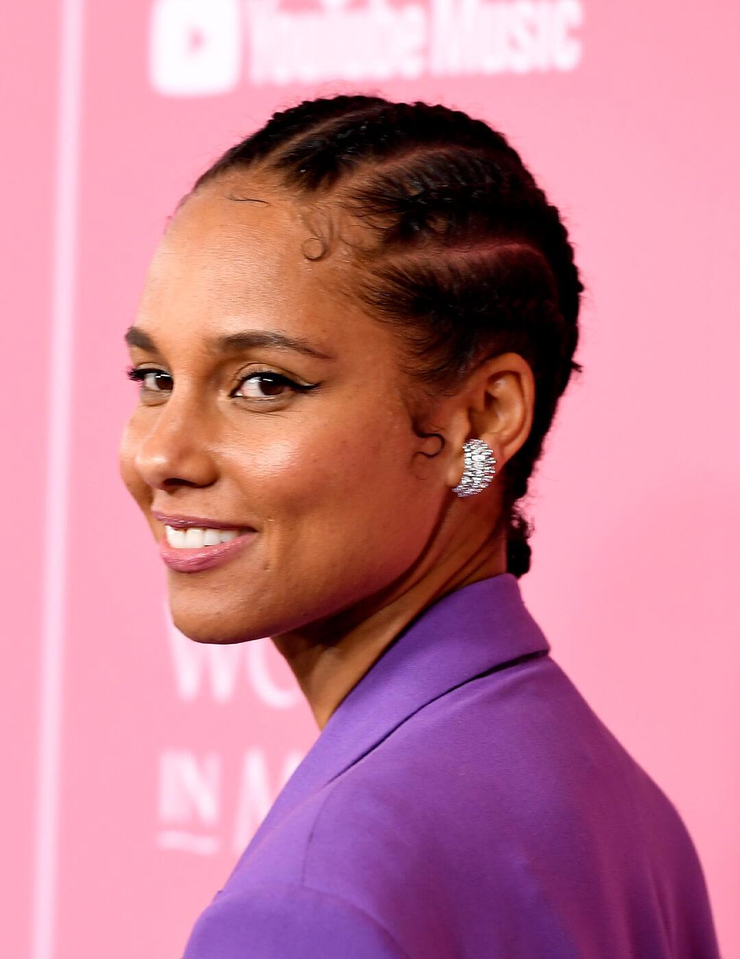 Alicia Keys wearing a cornrows hairstyle and a purple suit