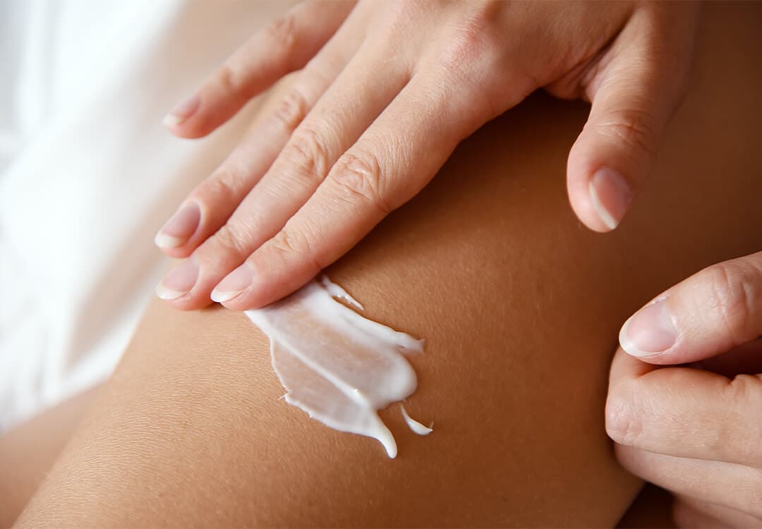 Close-up image of a woman's hand putting lotion on skin
