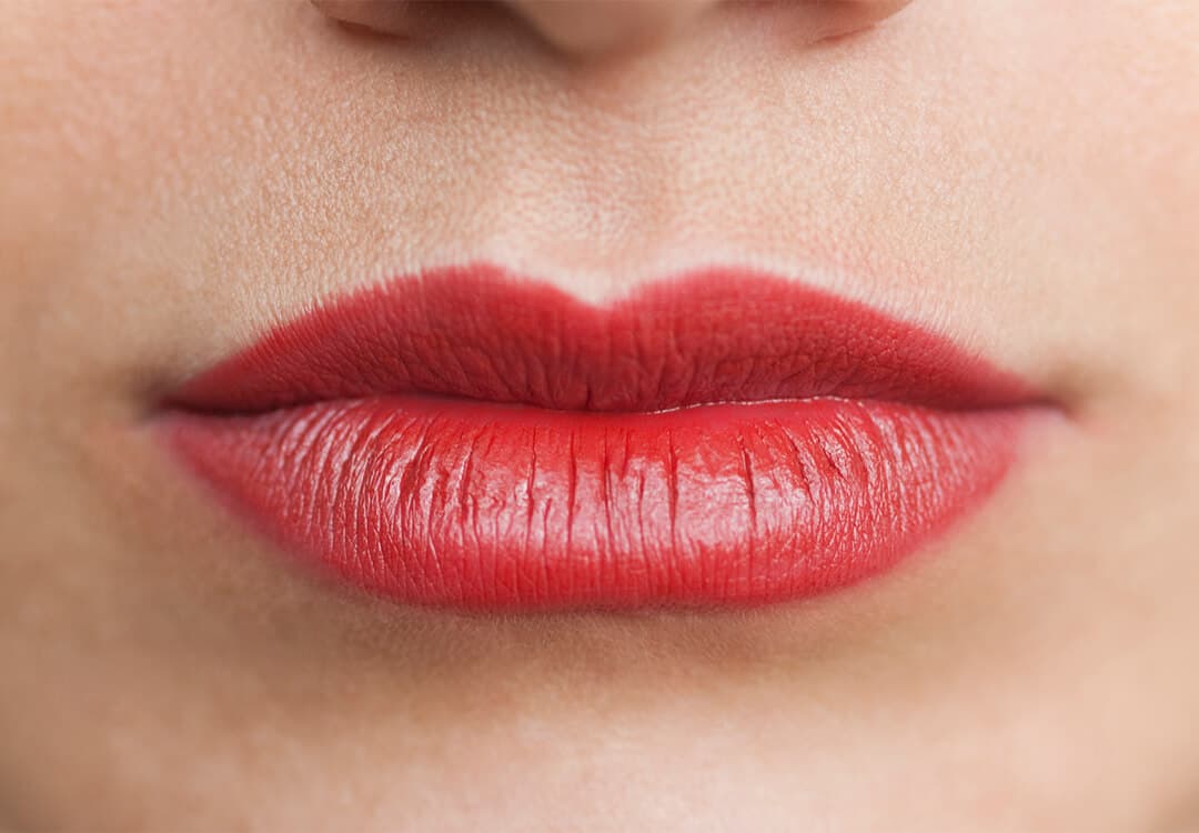 Close-up of a woman's wide lips with red lipstick