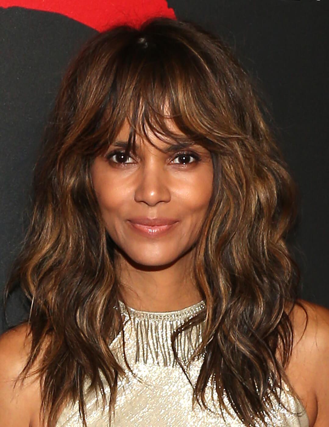 Halle Berry looking chic with a wavy hairstyle and silver dress
