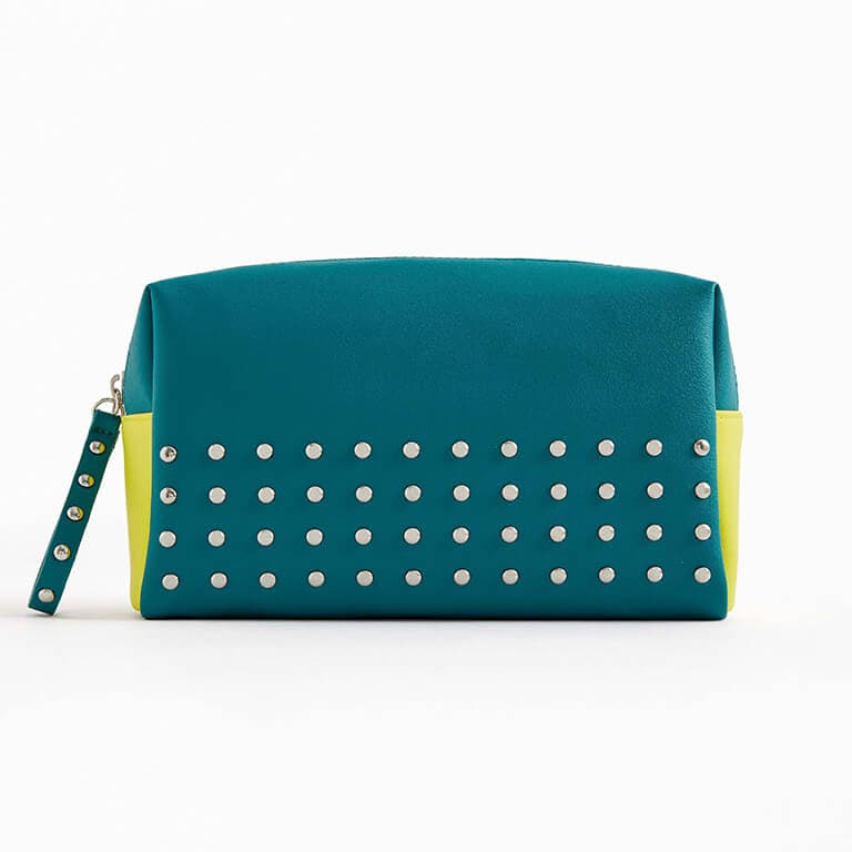 The March 2020 Glam Bag Ultimate bag is blue-green with silver studs and neon yellow accents