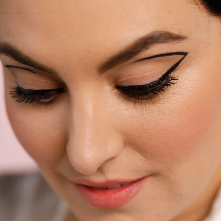 An image of a model rocking a negative space eyeliner look looking down