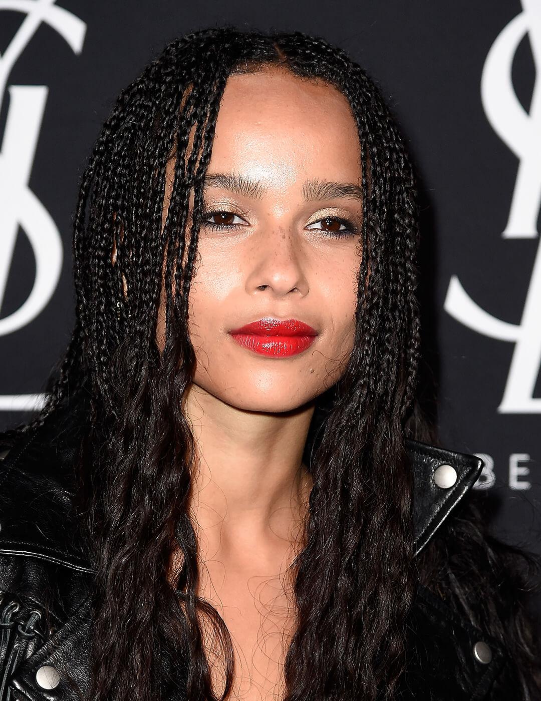 Zoe Kravitz rocking long braided hairstyle and natural makeup look paired with bold red lips