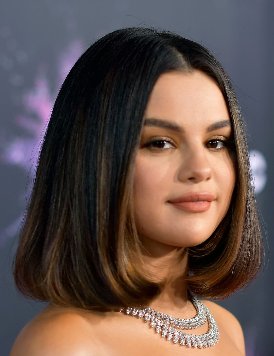 A photo of Selena Gomez appearing in her dark-colored hair paired with an elegant silver necklace