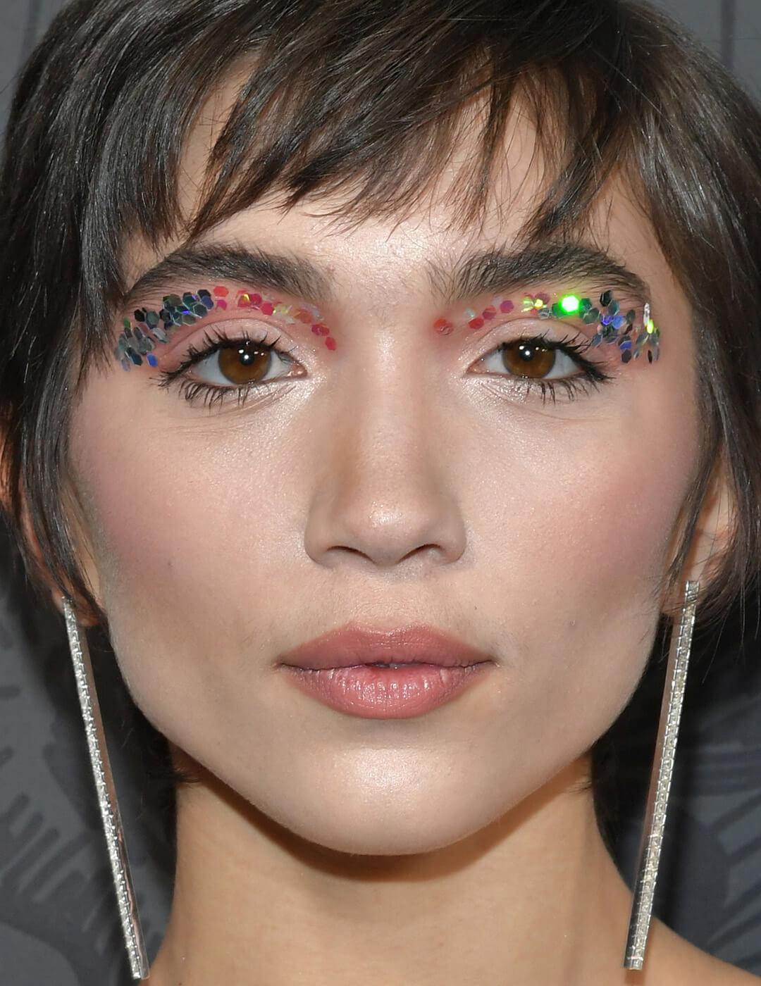Close-up of Rowan Blanchard rocking a rainbow sequin cut crease eye makeup look on the red carpet