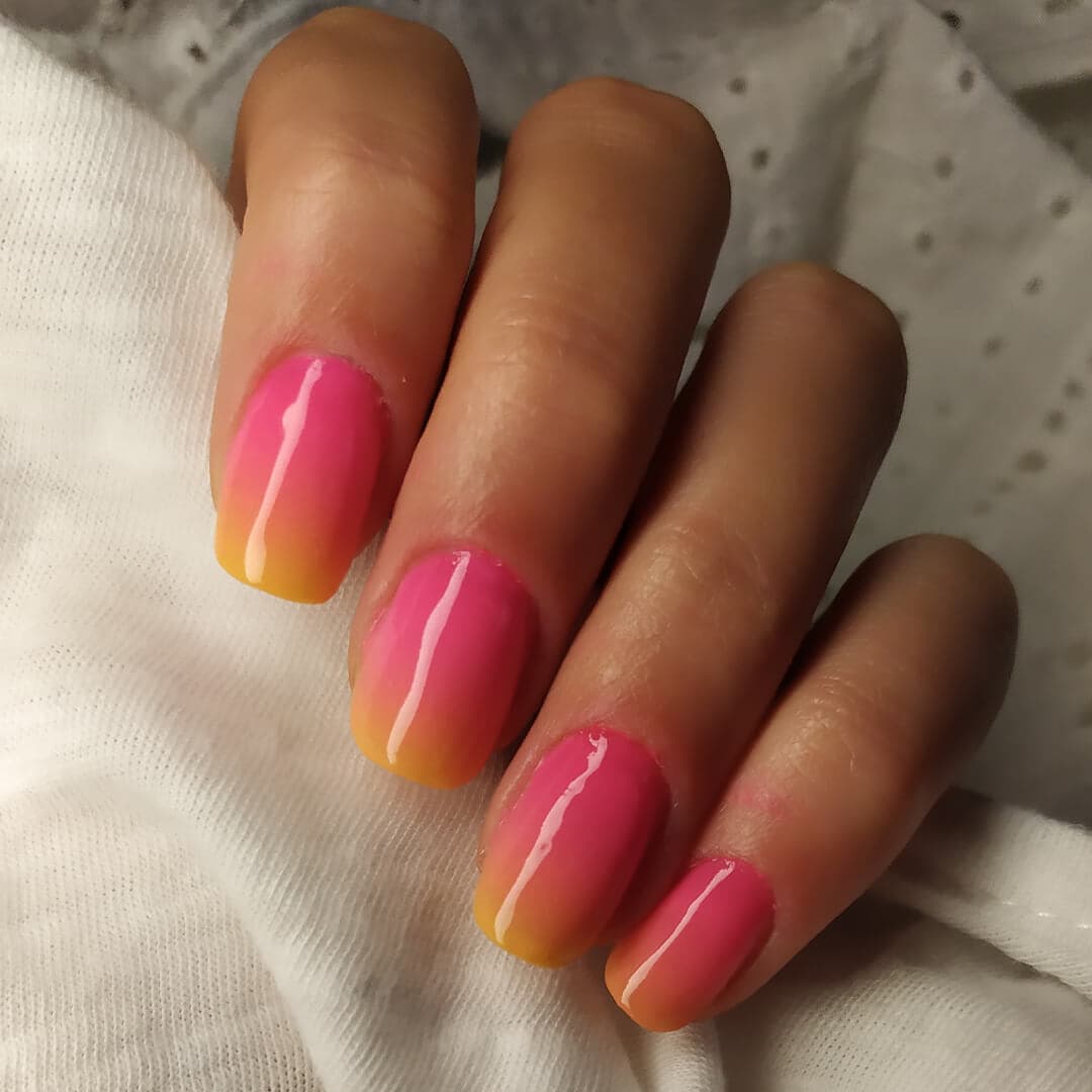 Close-up of woman's nails with sunset ombré nail art