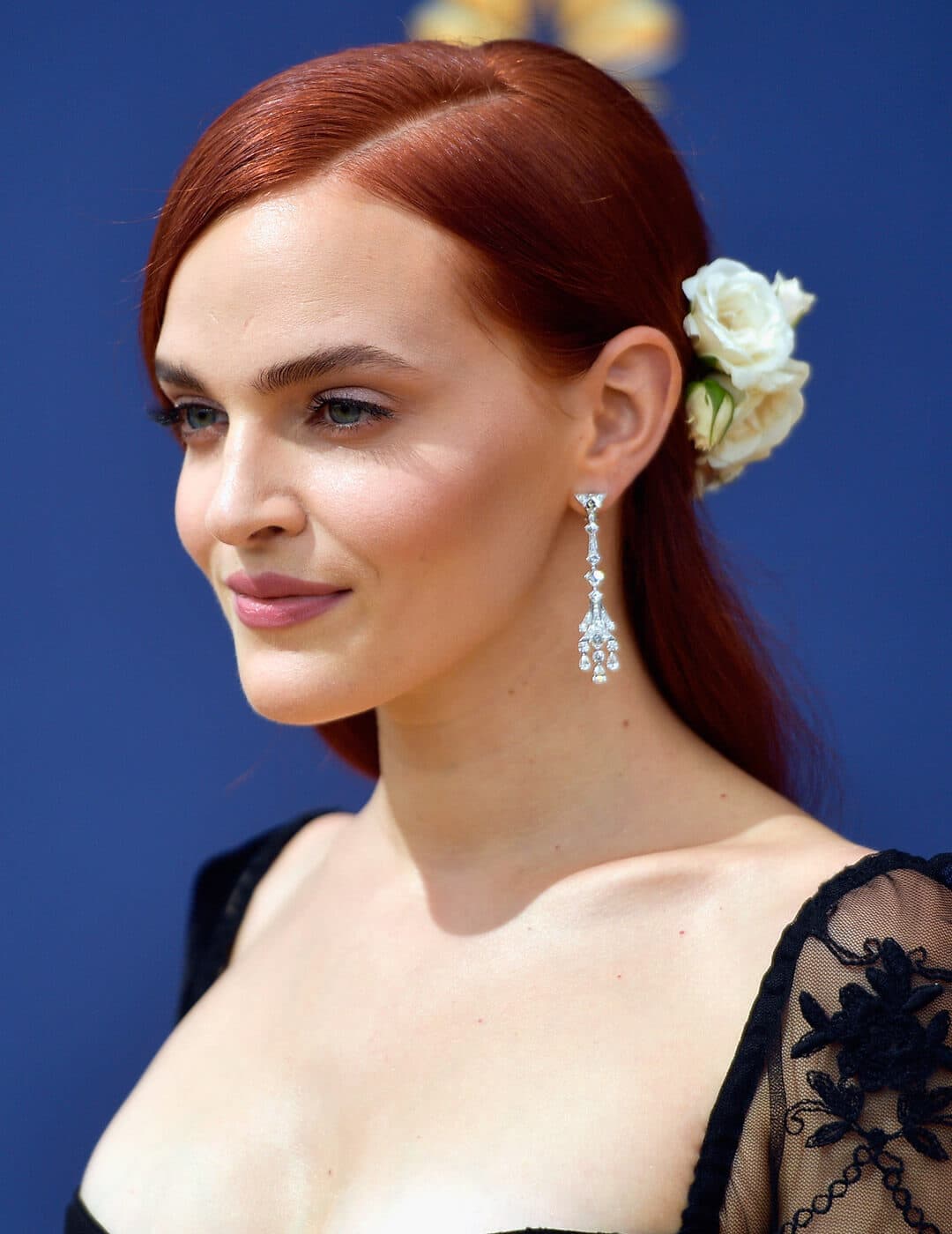 A photo of Madeline Brewer with a white rose hair accessory 