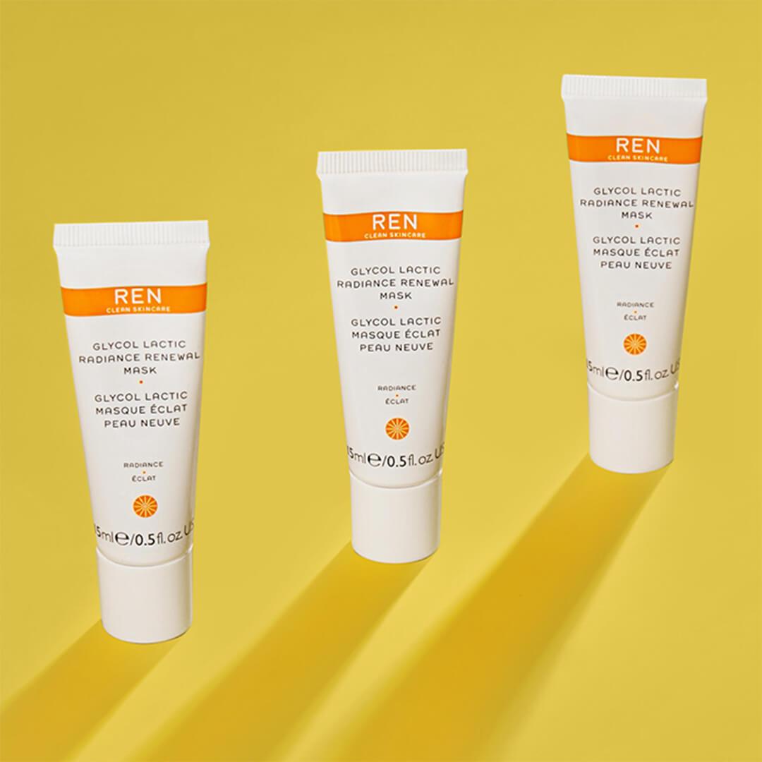 Three tubes of REN CLEAN SKINCARE Glycol Lactic Radiance Renewal Mask arranged on yellow background