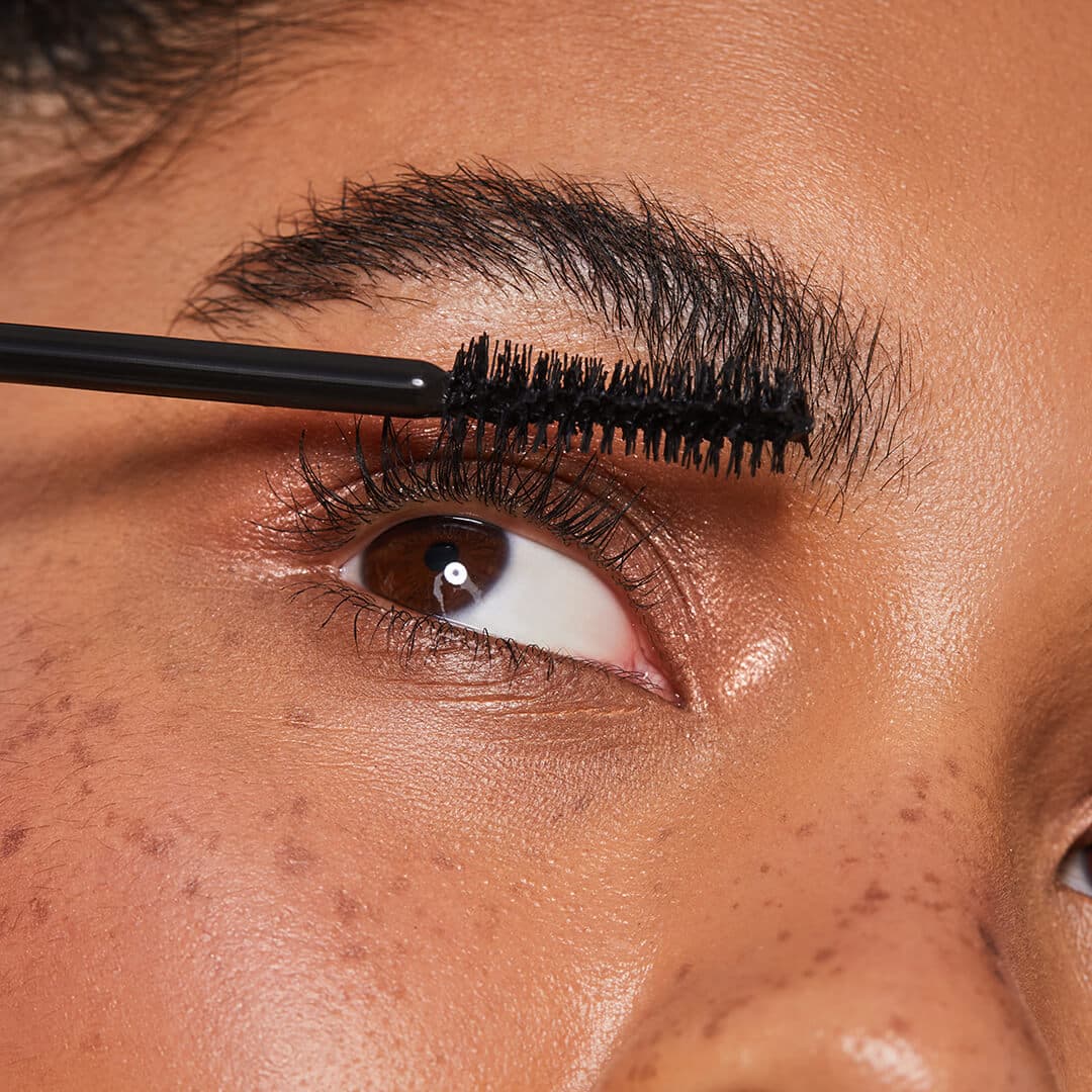 Close-up image of a model putting on mascara