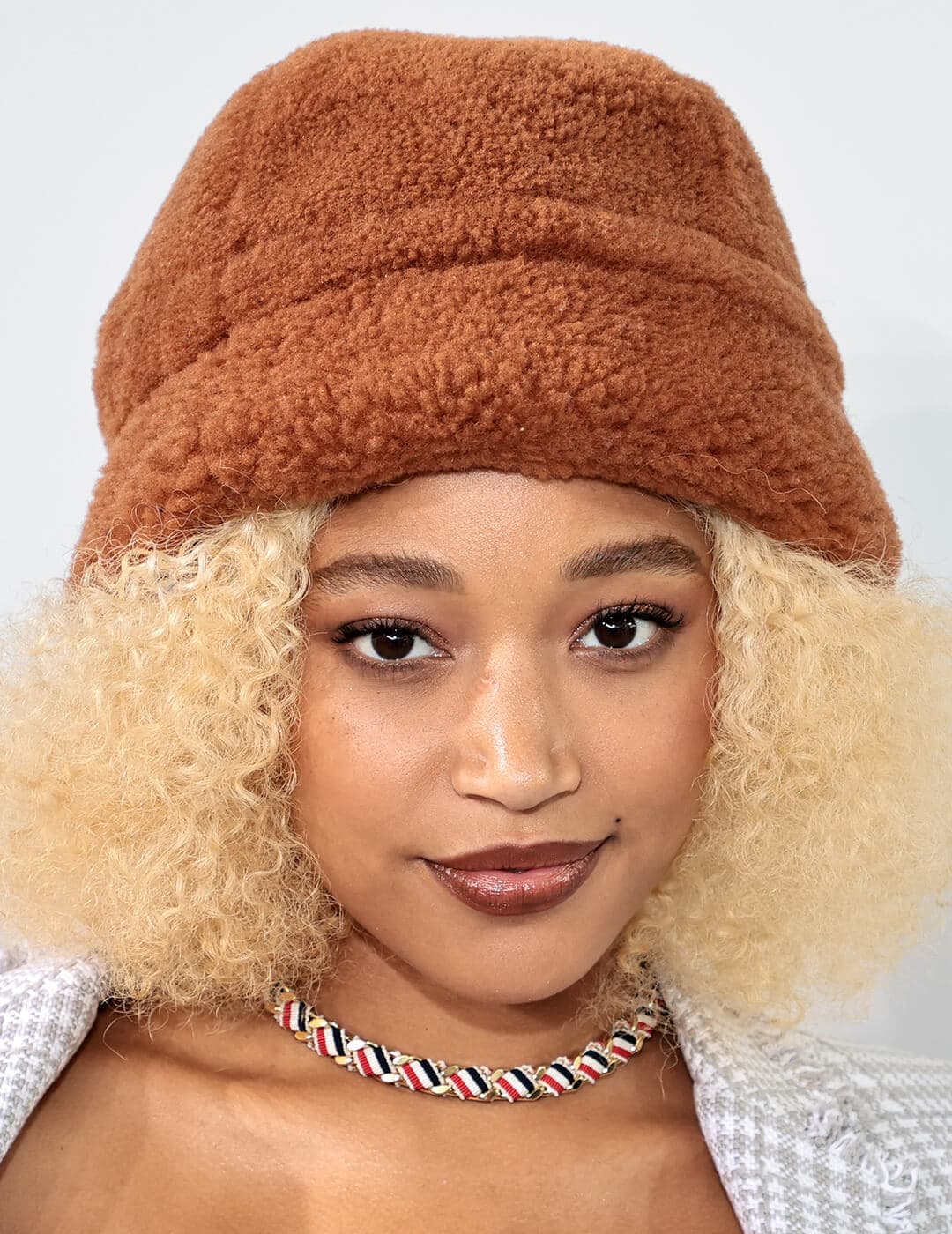 A photo of  Amandla Stenberg with a brown hat and brown curly hair