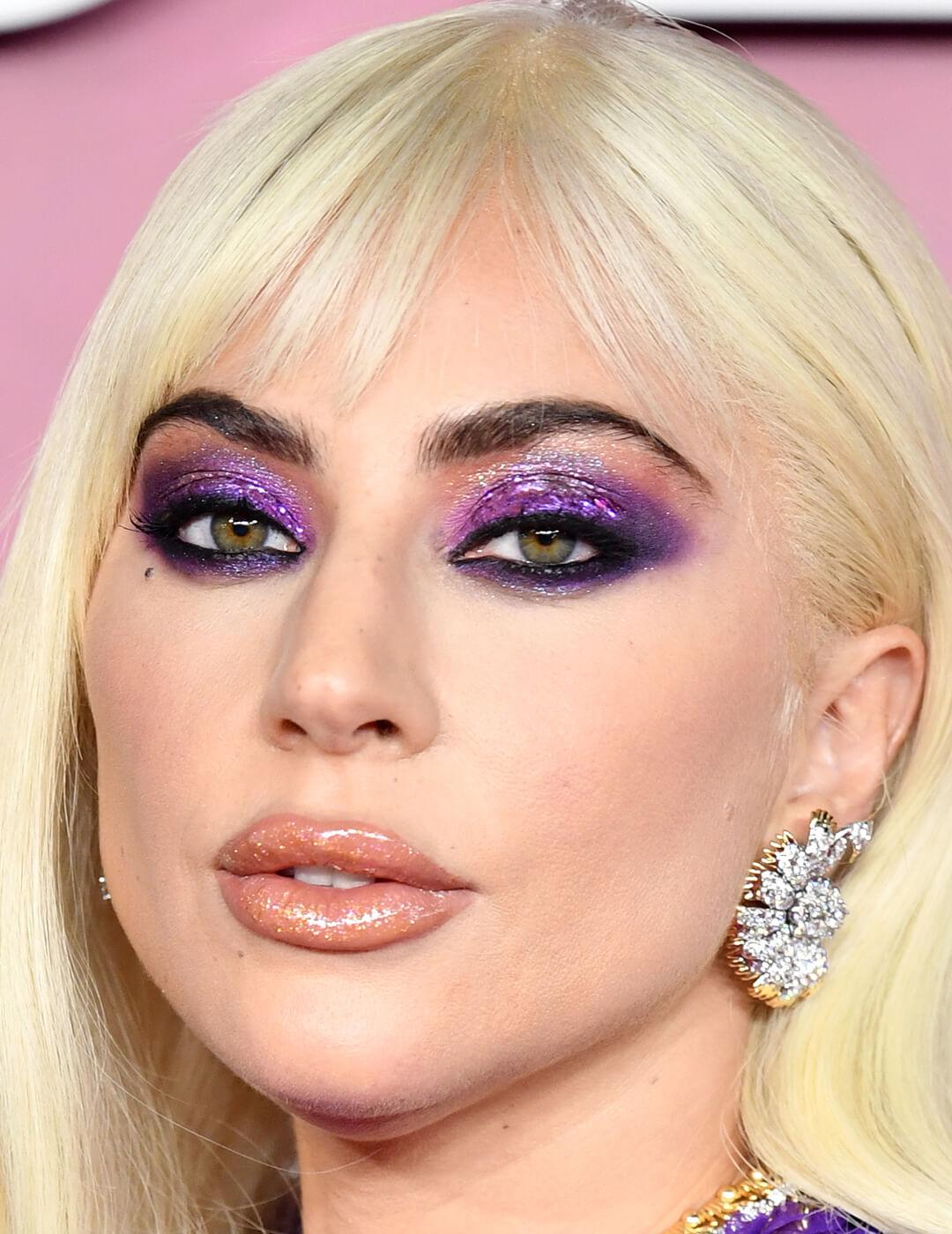 Lady Gaga rocking shimmery purple eyeshadow and glossy lips on the red carpet