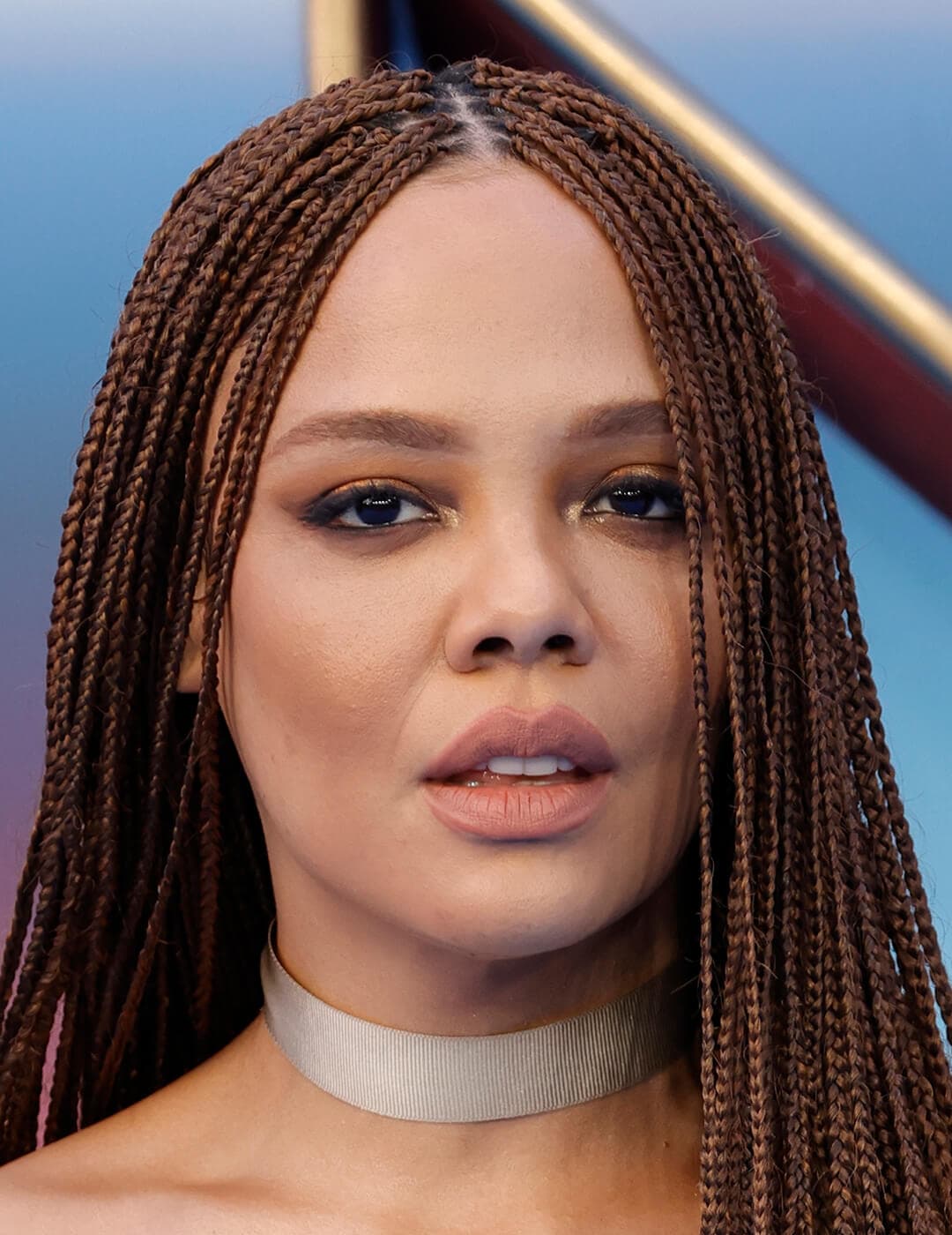 An image of Tessa Thompson wearing her braided brown hair and gold eye shadow