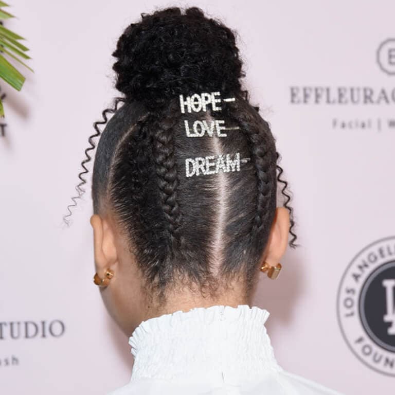 An image of Storm Reid's top bun and braids embellished with statement hair clips
