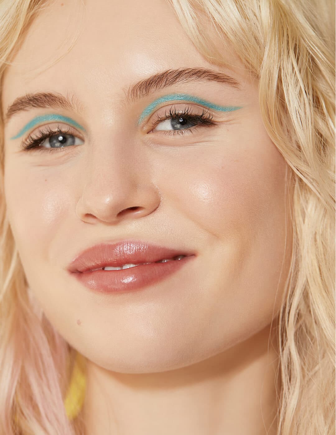 Close-up of a model rocking an aquamarine cut crease eye makeup look