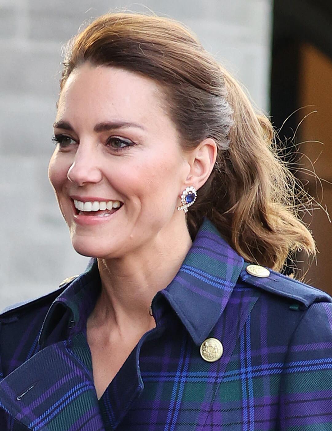 Catherine, Duchess of Cambridge rocking a pulled back ponytail hairstyle and blue plaid coat