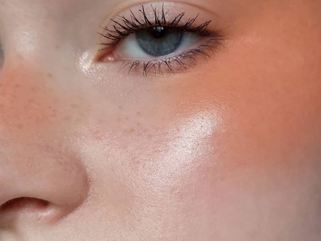 Close-up of a woman rocking a glowy, blush makeup look