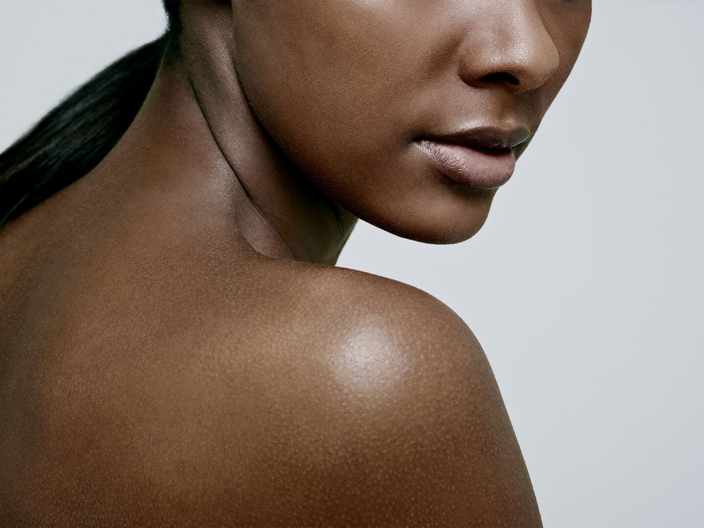 A close-up of a woman's bare shoulder and lower face, emphasizing her ...
