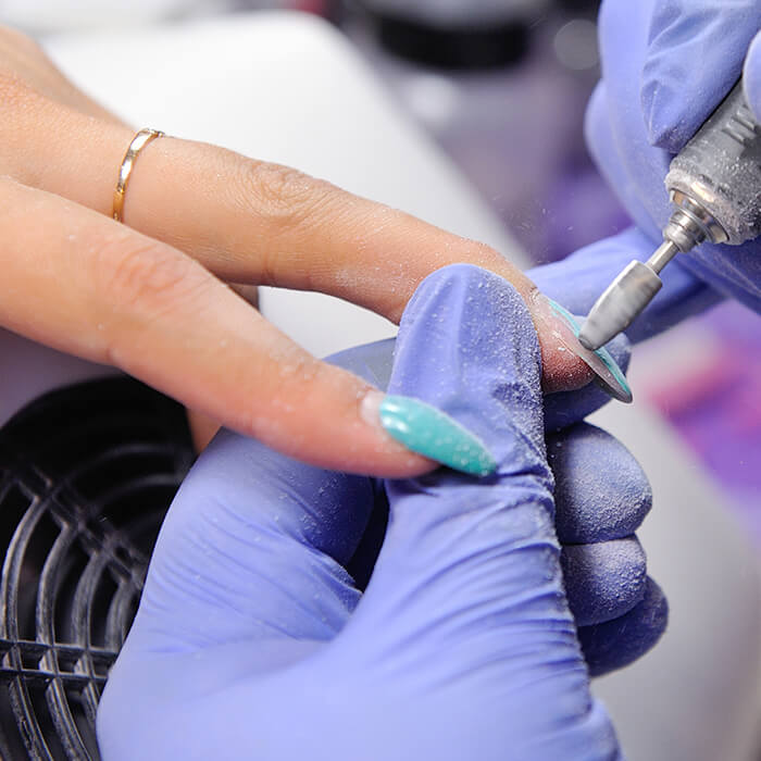 Repair old gel nails with a nail grinder in the nail salon