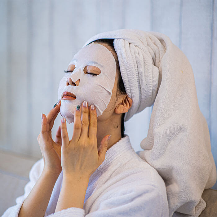 An image of a woman in a state of relaxation, with a purifying mask adorning her face