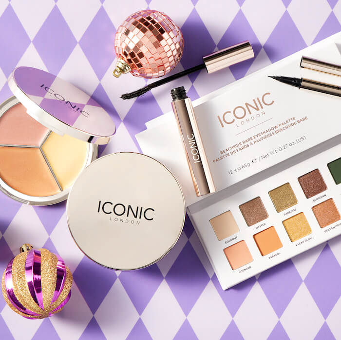 Beauty products from iconic london arranged with ornaments against colorful checkered background