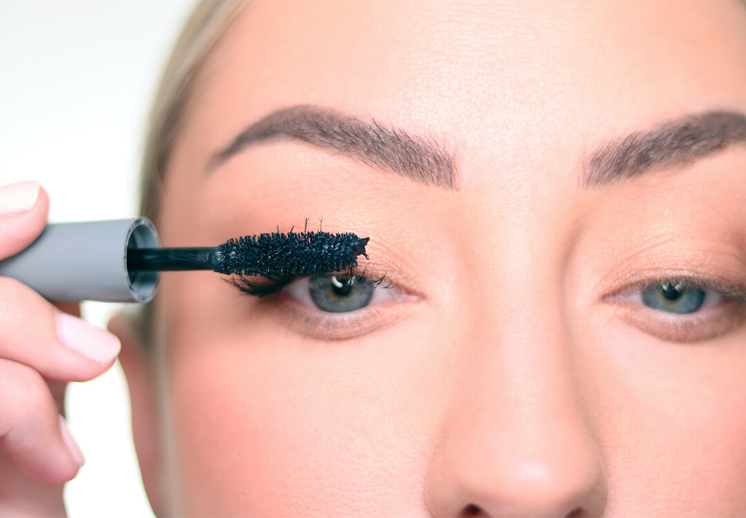 Close-up of Anne Baker applying mascara on her lashes