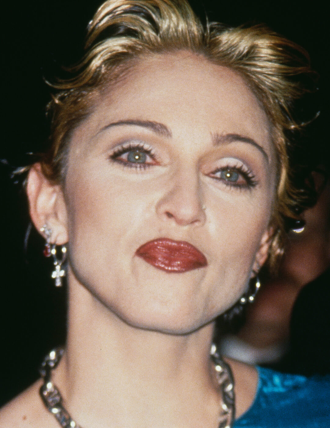 Younger Madonna rocking a cut crease eye makeup look and dark red lips