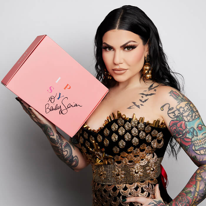 Bailey Sarian holding a signed pink IPSY box