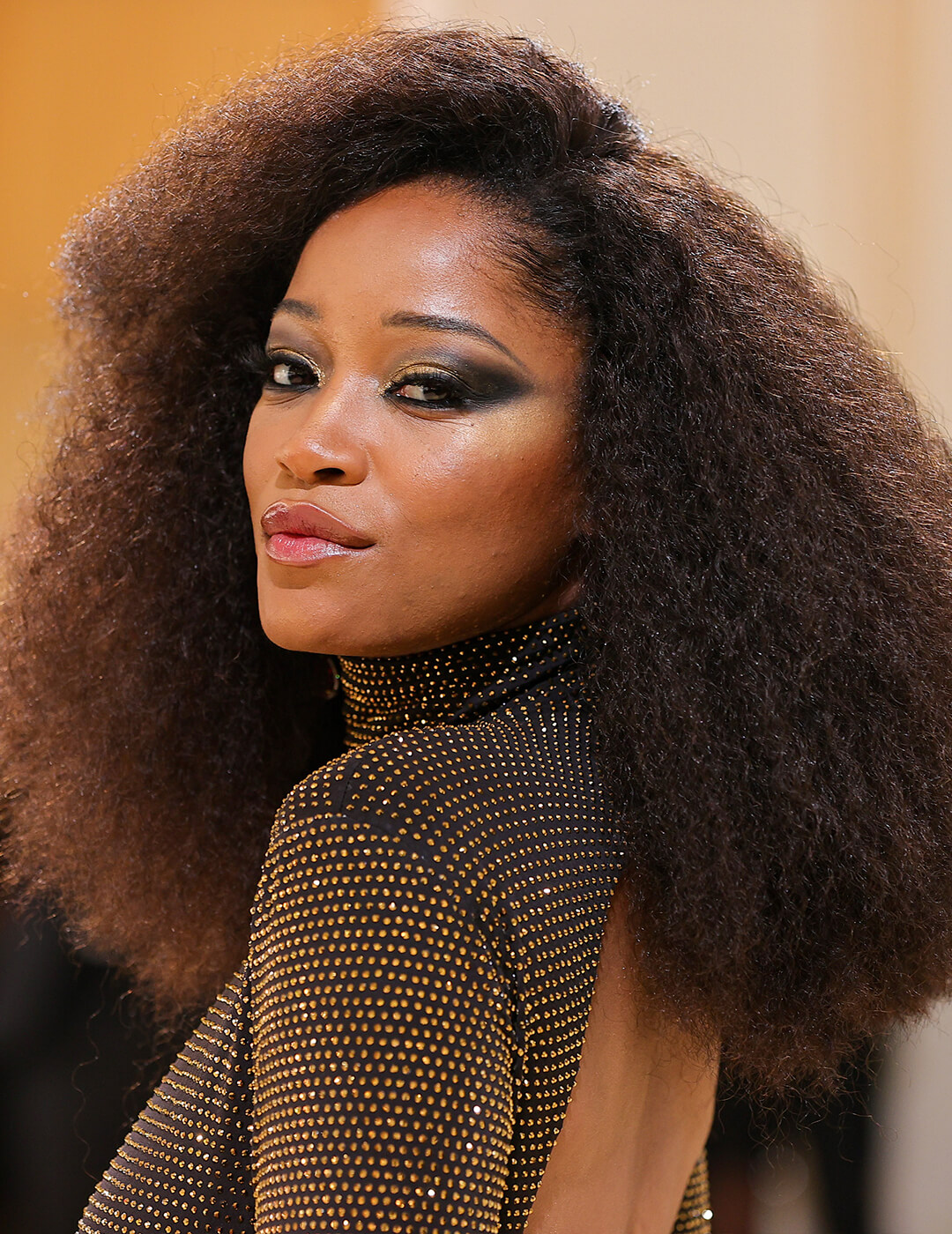 Keke Palmer rocking an afro and black and gold sequined dress