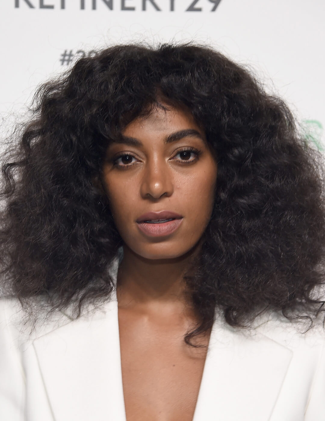 Solange Knowles rocking long, voluminuous curly hairstyle and white suit