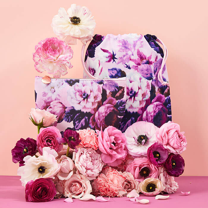 May 2022 Glam Bag and Glam Bag Plus bags and colorful flowers on pink background