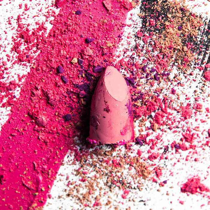 Crushed make-up products on white background