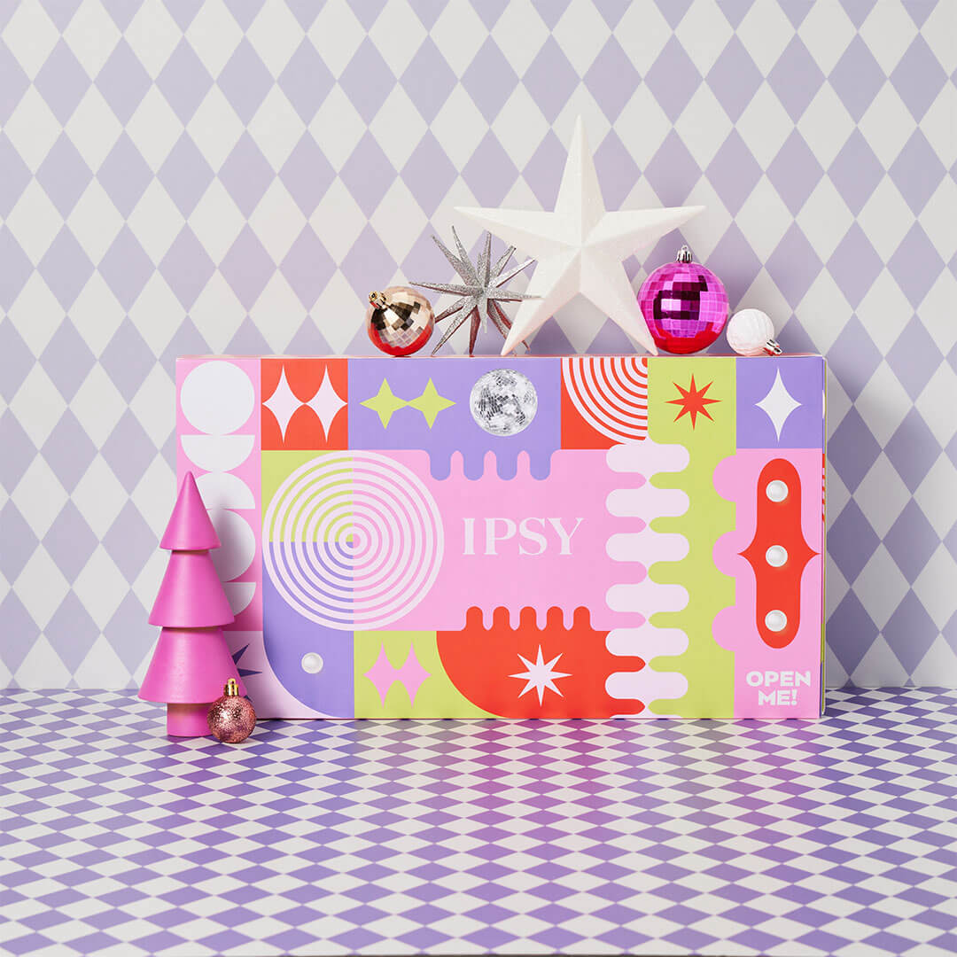 IPSY's 25-day advent calendar on a checkered background with holiday-themed decor around it.