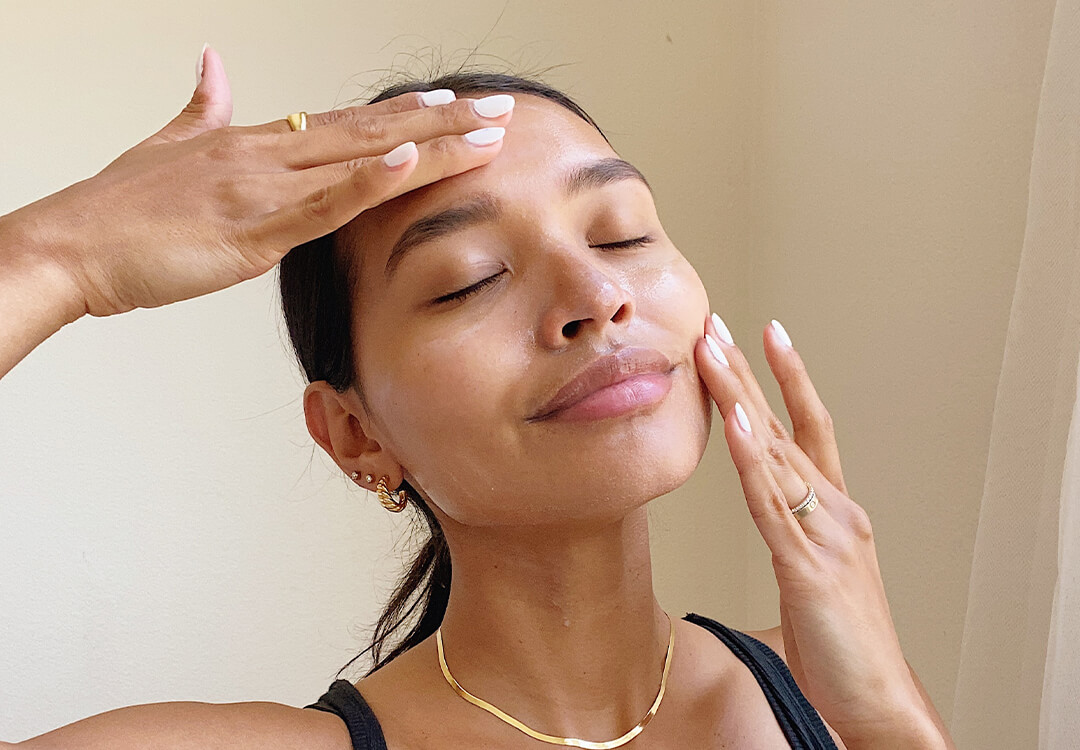 Image of a woman massaging her face with her hands