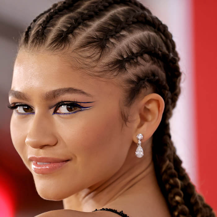 Close-up of Zendaya rocking a graphic eyeliner makeup look and cornrows hairstyle