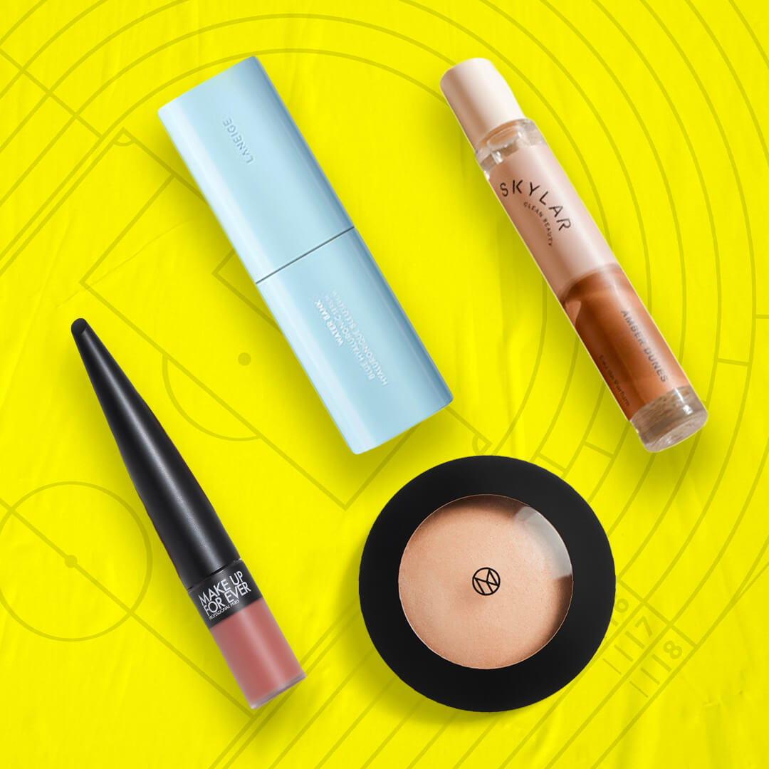 Skincare, makeup, and hair care products and tools from various brands scattered on yellow background