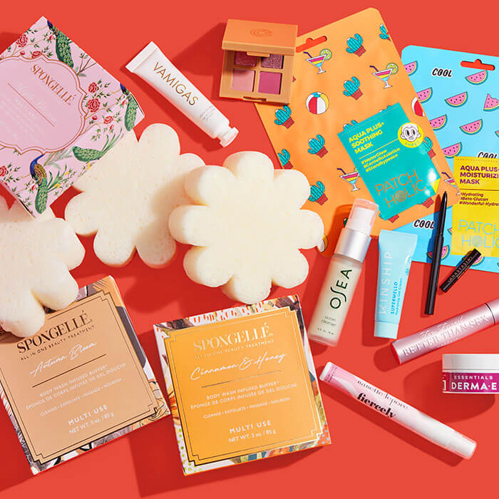 Beauty and makeup products from various brands scattered on red background