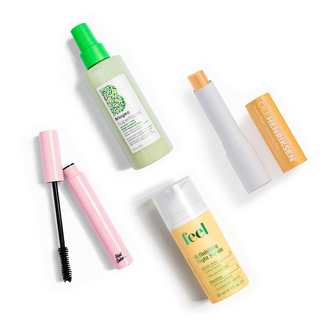 Skincare, makeup, and hair care products and tools from various brands scattered on white background