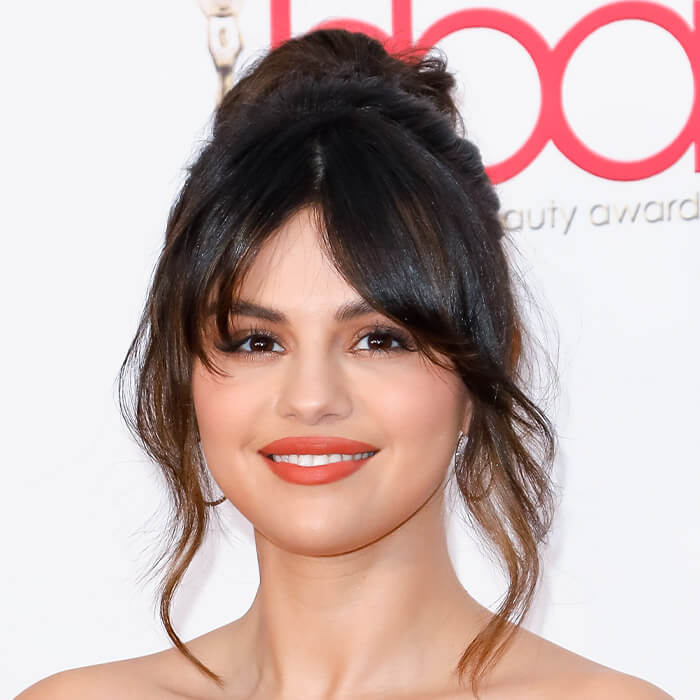 Close-up image of Selena Gomez rocking an updo with curtain bangs