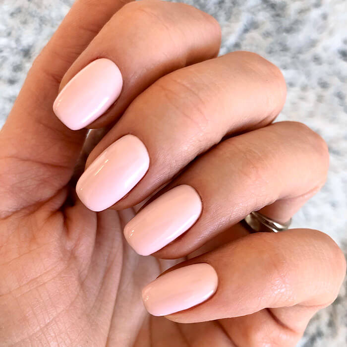 Close-up image of a woman's light pink mani