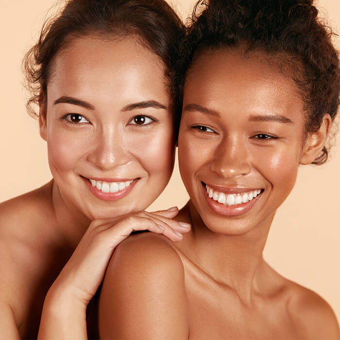 Beauty shot of two smiling young women with clear skin