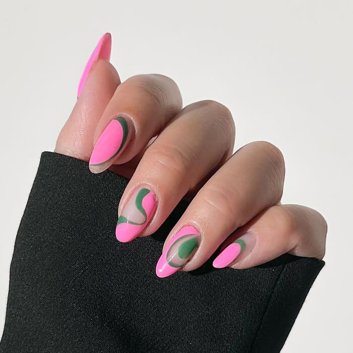 Close-up of a woman's hand with pink and green swirly nail art