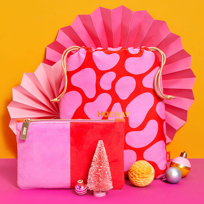 December 2022 IPSY Glam Bag and Glam Bag plus on orange and pink background with bright Christmas decors