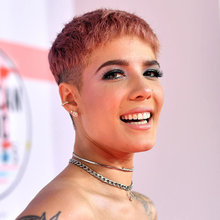 Halsey looking chic in a pink pixie cut hairstyle and pink eyeshadow with bold lashes makeup look