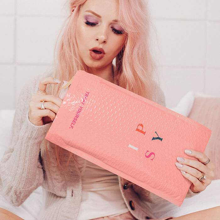 Image of a model opening an IPSY mailer