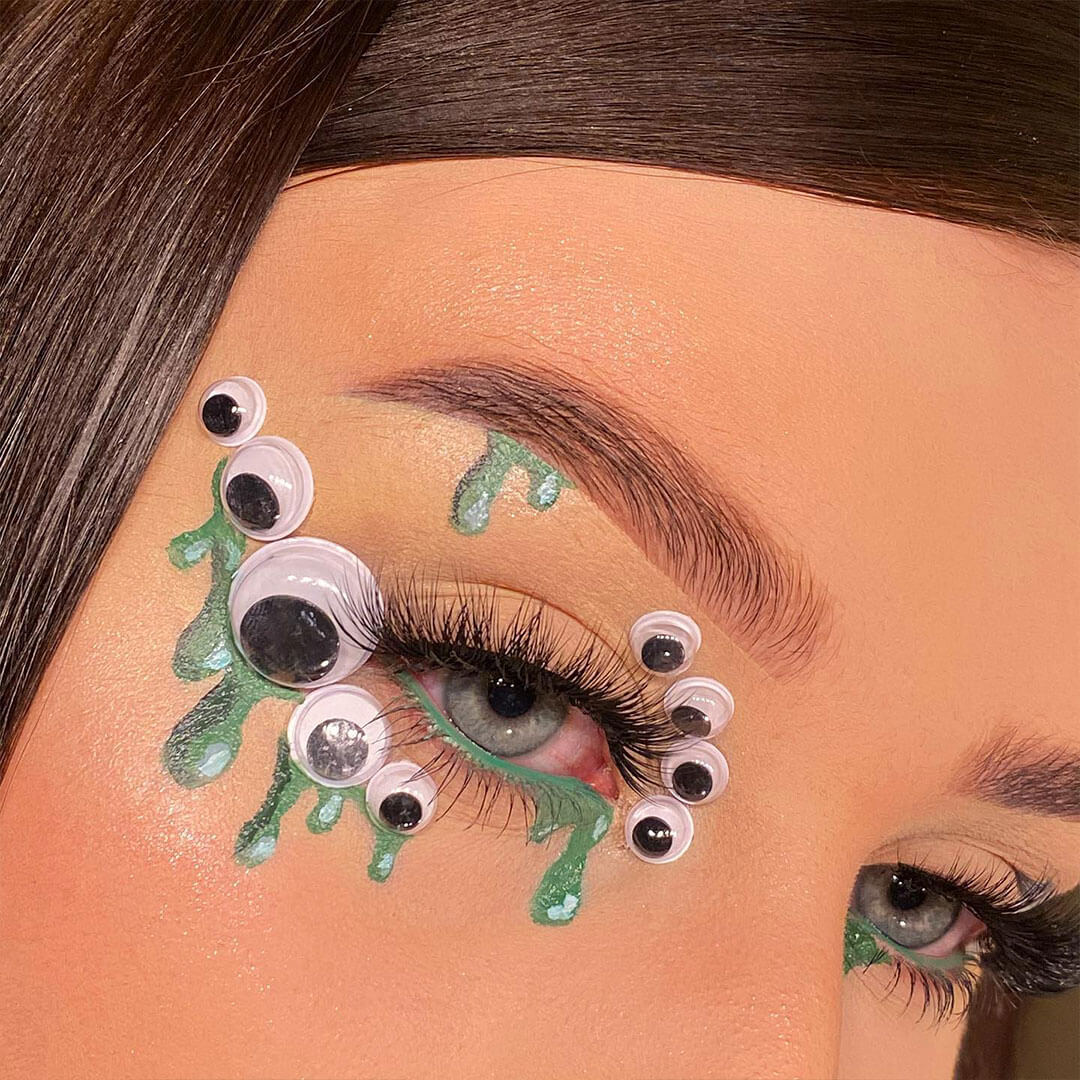 An image focused on a girl's eye featuring a sleek design with a gooey eye design and green accents eyeshadow